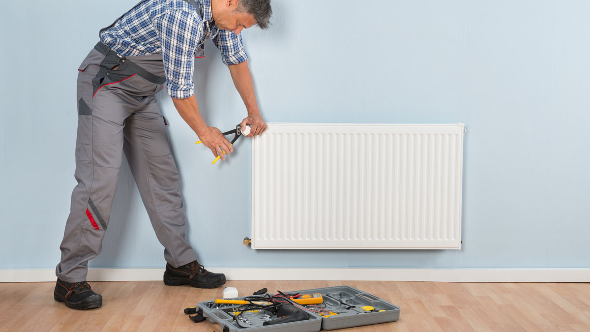 A plumber fixing a radiator